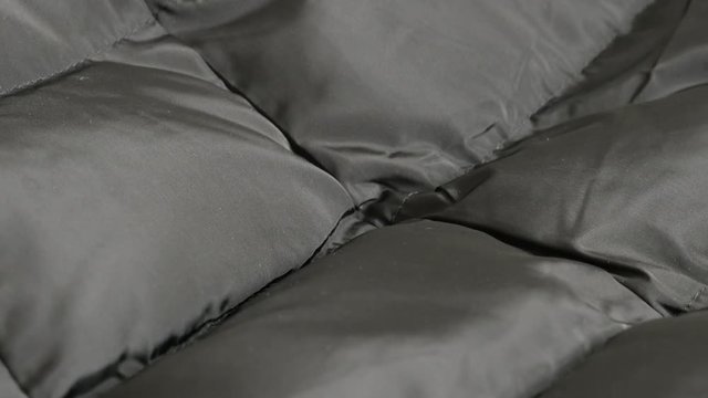 Slow tilt on padded jacket details and texture 4K 2160p 30fps UltraHD footage - Modern water resistant fabric of warm winter parka 3840X2160 UHD tilting video
