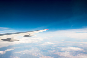 Obraz premium The wing of an airplane flying in the sky