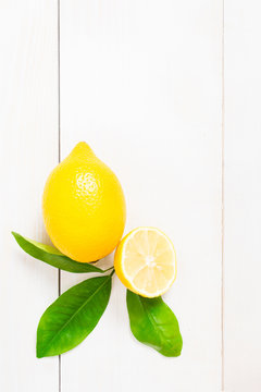 Lemon with leaves on the wooden table