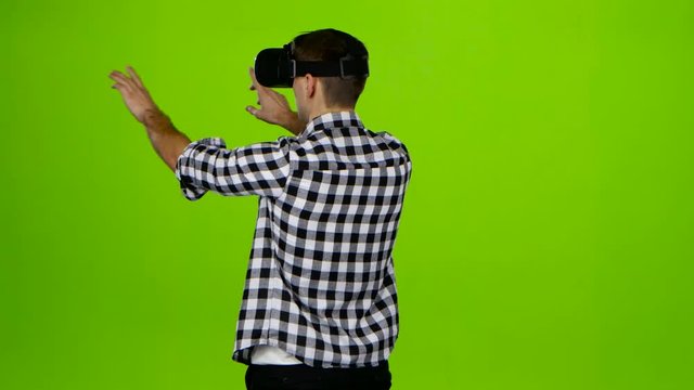 Man in vr glasses on head. Back view. Green screen