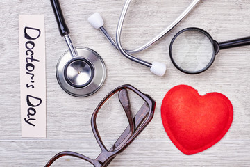 Stethoscope, glasses and magnifying glass. Greeting card for a doctor.