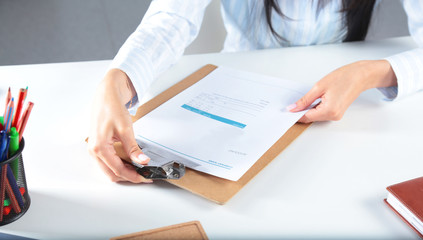 Business women sitting on desk and writing a paper