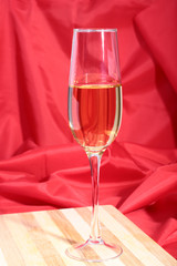 Glass of white wine on red background