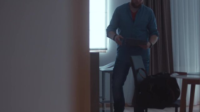 WIDE Caucasian male packing travel bag at home. 4K UHD RAW edited footage