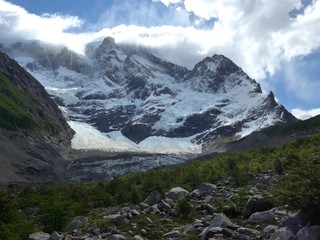 The beautiful natural landscape of Valle Frances, jagged peaks, towering cliffs, swirling wind and clouds, glaciers and blue sky in Torres del Paine National Park.