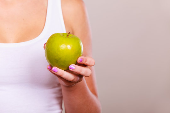Fit woman holding apple fruit, dieting concept
