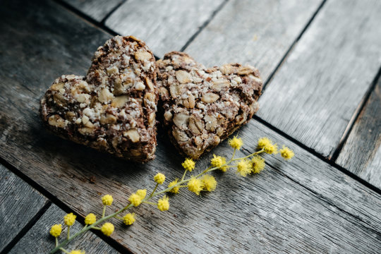 Couple Cookies In The Shape Of Hearts With Sprigs Of Mimosa. Spring Concept