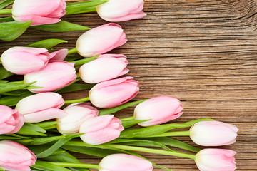 Pink tulips on wooden background. Top view, copy space