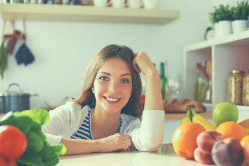 Young woman standing near desk in the kitchen