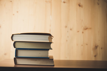 Stack of books on wooden table.