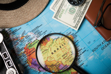 Close up of Money,Magnifier,hat and vintage camera on world map background. Traveling concept.