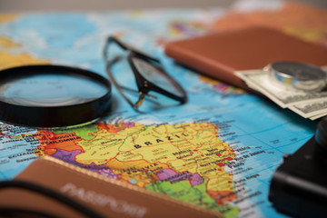 Close up of travel accessories on world map background.