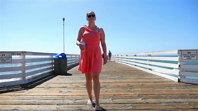 Two high quality videos of woman at the pier in California in slow motion