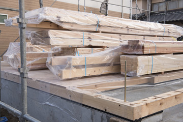 木材の積まれた戸建住宅の新築工事現場
