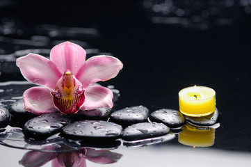 Fototapeta na wymiar Pink orchid ,yellow candle with therapy stones 