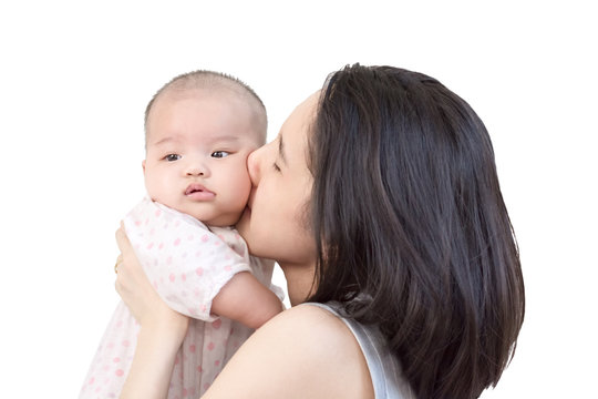 Portrait of happy asian mother kissing and hugging her cute little baby. Isolated on white background