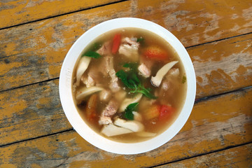 Thai Suppe im Teller auf einem rustikalen Tisch