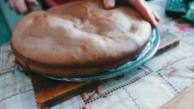 Woman with knife cuts the cake