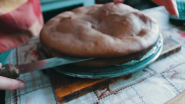 Woman with knife cuts the cake