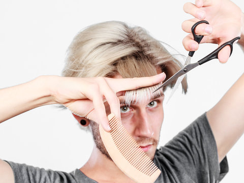 Man with scissors and comb creating new coiffure
