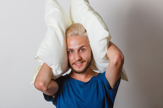 Man playing with pillows, good sleep concept