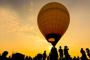 Silhouette of people  standing with hot air balloon at sunset