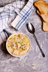 Chicken noodle soup with omelette in white ceramic bowl