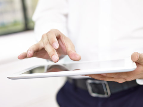 closeup of hand of a business person using a tablet