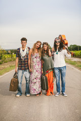 Four hippie friends walking on countryside