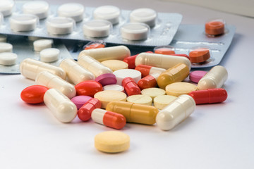 A lot of tablets for treatment of diseases are scattered on a table at home. Other drugs on the table. Vitamins on a table at home.