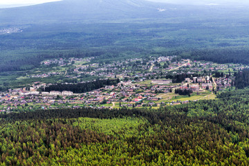 Obraz premium Urban panorama aerial view. City surrounded by forest