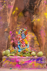 Krishna statue with flowers and offerings during Holi celebration in India