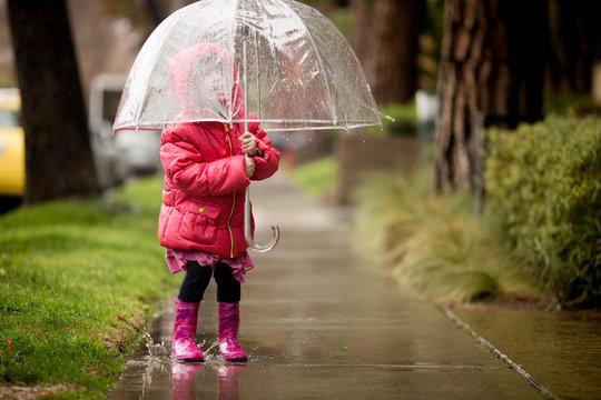 A young girl is playing in the much needed California rain.