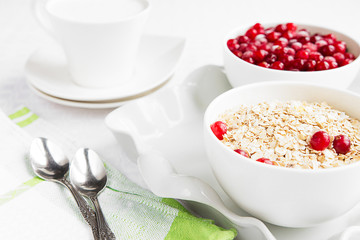 Rolled oats, porridge and cranberries for a healthy breakfast in a rustic style