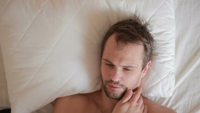 A Man With A Fever Is Lying In Bed At Home