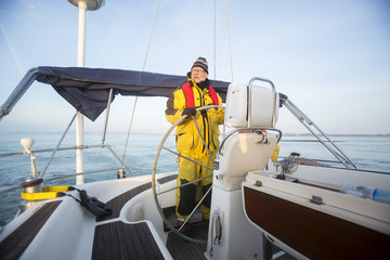 Man Steering Wheel Of Yacht In Sea