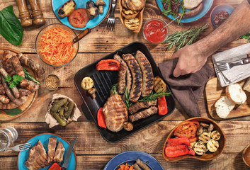 On the wooden table different food cooked on the grill