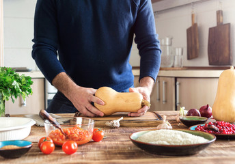 Man preparing healthy food of squash with rice and cranberries