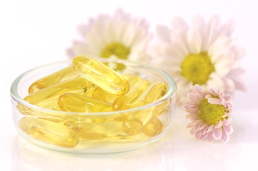 Obraz na płótnie Canvas Soft gelatin capsules of dietary supplement in warm light tone.