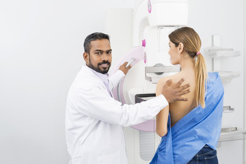 Fototapeta na wymiar Doctor Standing Assisting Patient Undergoing Mammogram X-ray Tes
