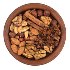 Mixture of nuts in a brown plate. Isolated on white background.