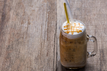 Coffee with straw on the wooden background
