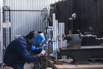 Side view of worker with welding machine