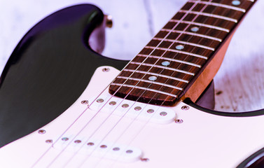 Electric guitar on an white wooden board, selective focus, horizontal
