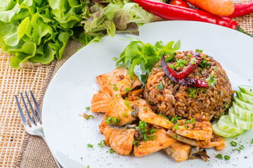 chinese cuisine, salt salmon fish and egg fried rice and vegetables with ingredients on rustic background.