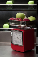Apples on weighing scales in the kitchen at home