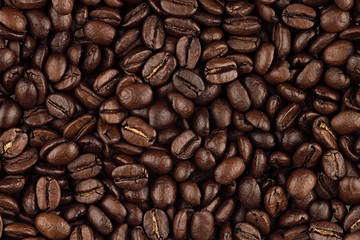 Roasted coffee beans closeup top view as background.