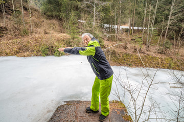 man having fun near frozen river