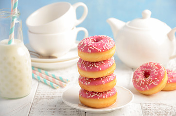 Baked donuts with pink glaze and sprinkles, selective focus