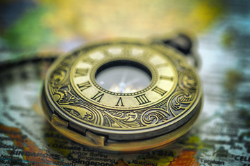 Fototapeta na wymiar vintage pocket watch on old-fashioned world map background